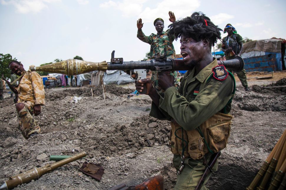 Soldiers of the Sudan People Liberation Army (SPLA) celebrate while standing in trenches in Lelo, outside Malakal, South Sudan