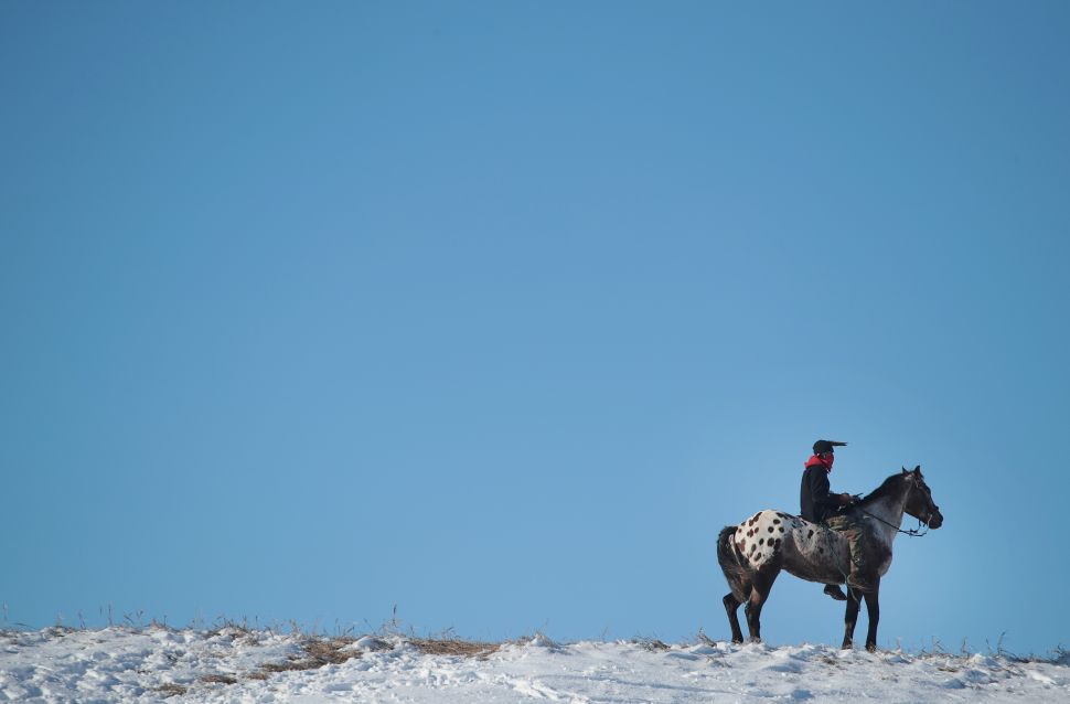 An Native American activist rides along a ridge which overlooks the edge of the Standing Rock Sioux Reservation on December 4, 2016. Activists from around the country gathered at the camp for several months trying to halt the construction of the Dakota Access Pipeline.