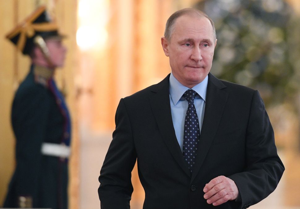 Russian President Vladimir Putin (C) walks prior to a State Council meeting at the Kremlin in Moscow on December 27, 2016. / AFP / POOL / NATALIA KOLESNIKOVA 
