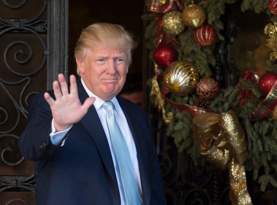 US President-elect Donald Trump waves to the media after meeting with David Rubenstein, co-founder of Carlyle Group December 28, 2016 at Mar-a-Lago in Palm Beach, Florida. / AFP / DON EMMERT 