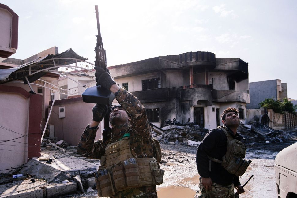 An Iraqi special forces Counter Terrorism Service member shoots at a drone flown by Islamic State group jihadists (IS) in Mosul on January 8, 2017, as an ongoing military operation against the militants continues.