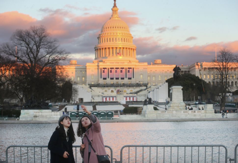 WASHINGTON, DC - JANUARY 18: PEople take photos as the sun sets on the West Front of the U.S. Capitol building ahead of inauguration ceremonies there for President-elect Donald Trump on January 18, 2017 in Washington, DC. Trump will be sworn in as the 45th U.S, president on January 20. 