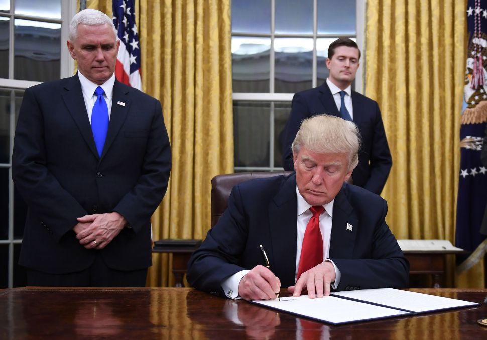 President Donald Trump signing an executive order in the Oval Office of the White House 