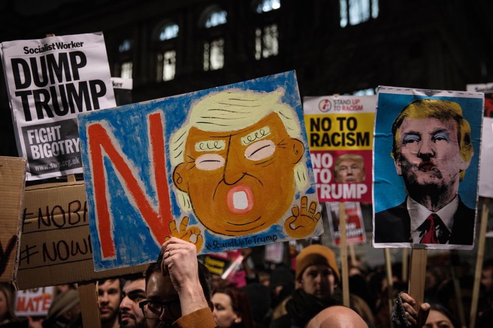LONDON, ENGLAND - JANUARY 30: Demonstrators hold up placards during a protest outside Downing Street against U.S. President Donald Trump's ban on travel from seven Muslim countries on January 30, 2017 in London, England. President Trump signed an executive order on Friday banning immigration to the USA from seven Muslim countries. This led to protests across America and, today, the UK. A British petition asking for the downgrading of Trump's State visit passed one million signatures this morning.