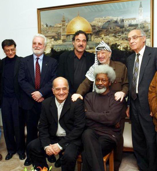 Palestinian leader Yasser Arafat (2ndR)) poses with a group of international intellectuals in March 2002.The group includes from L fo R standing: Palestinian poet Mahmoud Darwish, US writer Russell Banks, US film director Oliver Stone, Portuguese Nobel literature laureate Jose Saramago and seated fellow Nobel literature laureate Nigerian dissident Wole Soyinka (R).