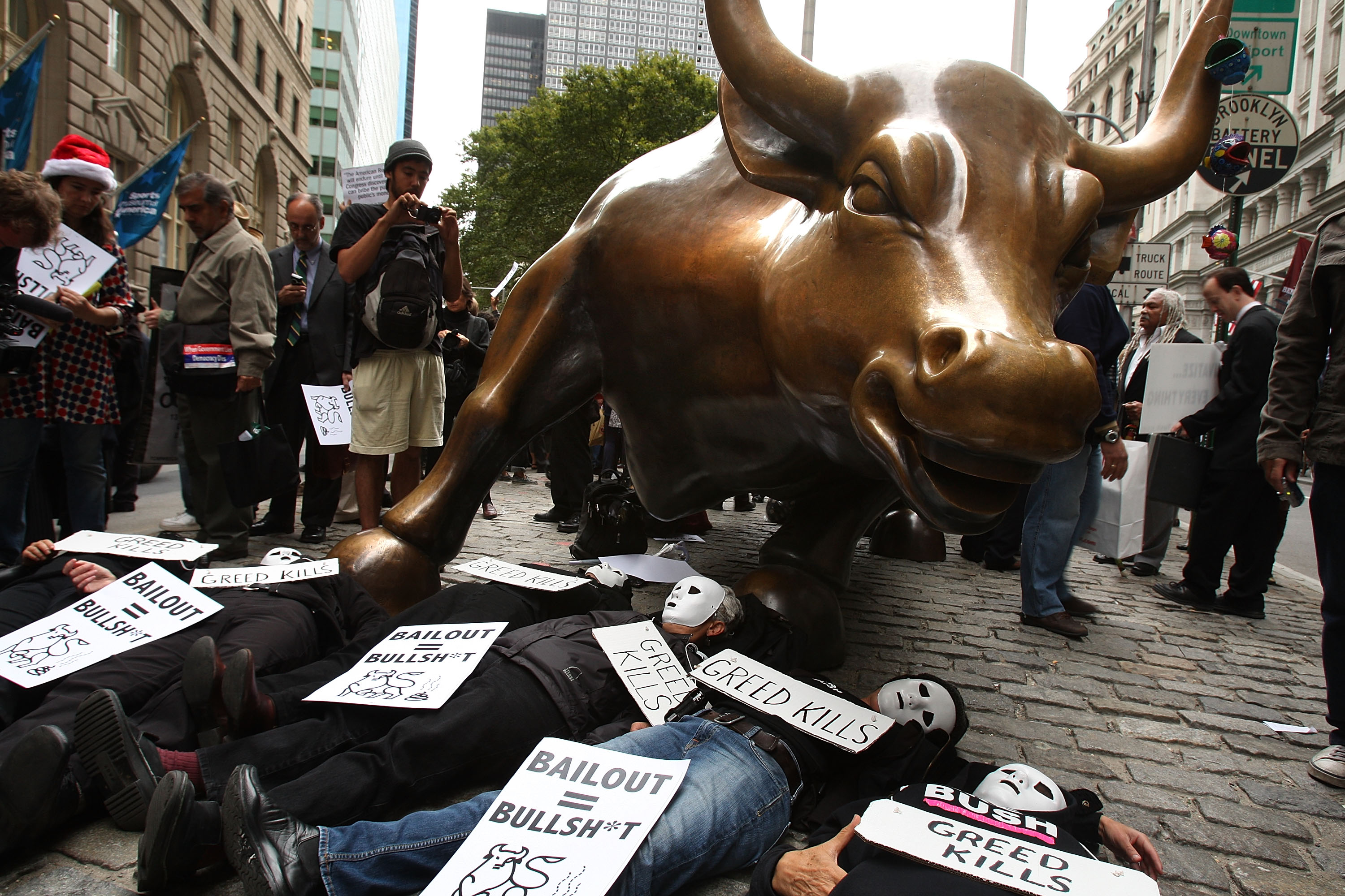 People lay underneath the iconic Wall Street bull during a rally in the financial district in New York City.