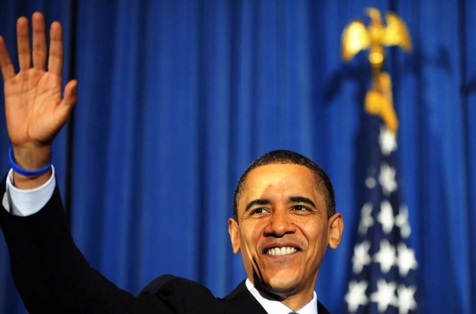 US President Barack Obama waves at the audience members during a rally celebrating the passage and signing the Affordable Care Act in 2010 