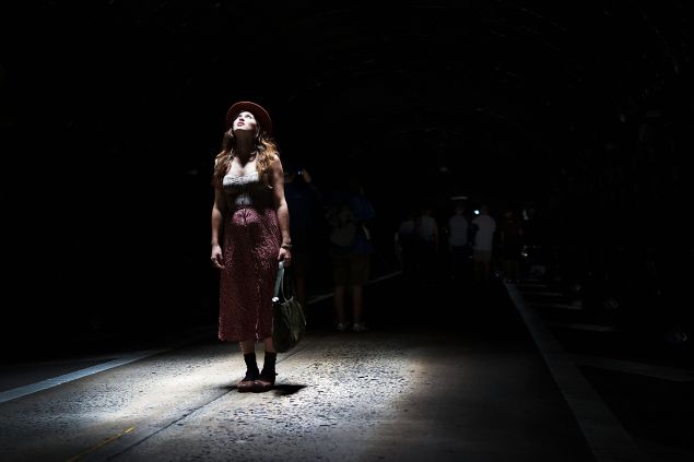 NEW YORK, NY - AUGUST 03: A woman pauses under a light inside the Park Avenue Tunnel after it has been temporarily transformed into an art exhibition for pedestrians on August 3, 2013 in New York City. Part of New York City's Summer Streets program, people were able to walk through the 1,300 foot-long tunnel to experience a voice-activated light show. The tunnel, which dates to the 1830's, carries one lane of northbound car traffic from East 33rd Street to East 40th Street. Artist and creator Rafael Lozano-Hemmer is known for his large-scale interactive art.