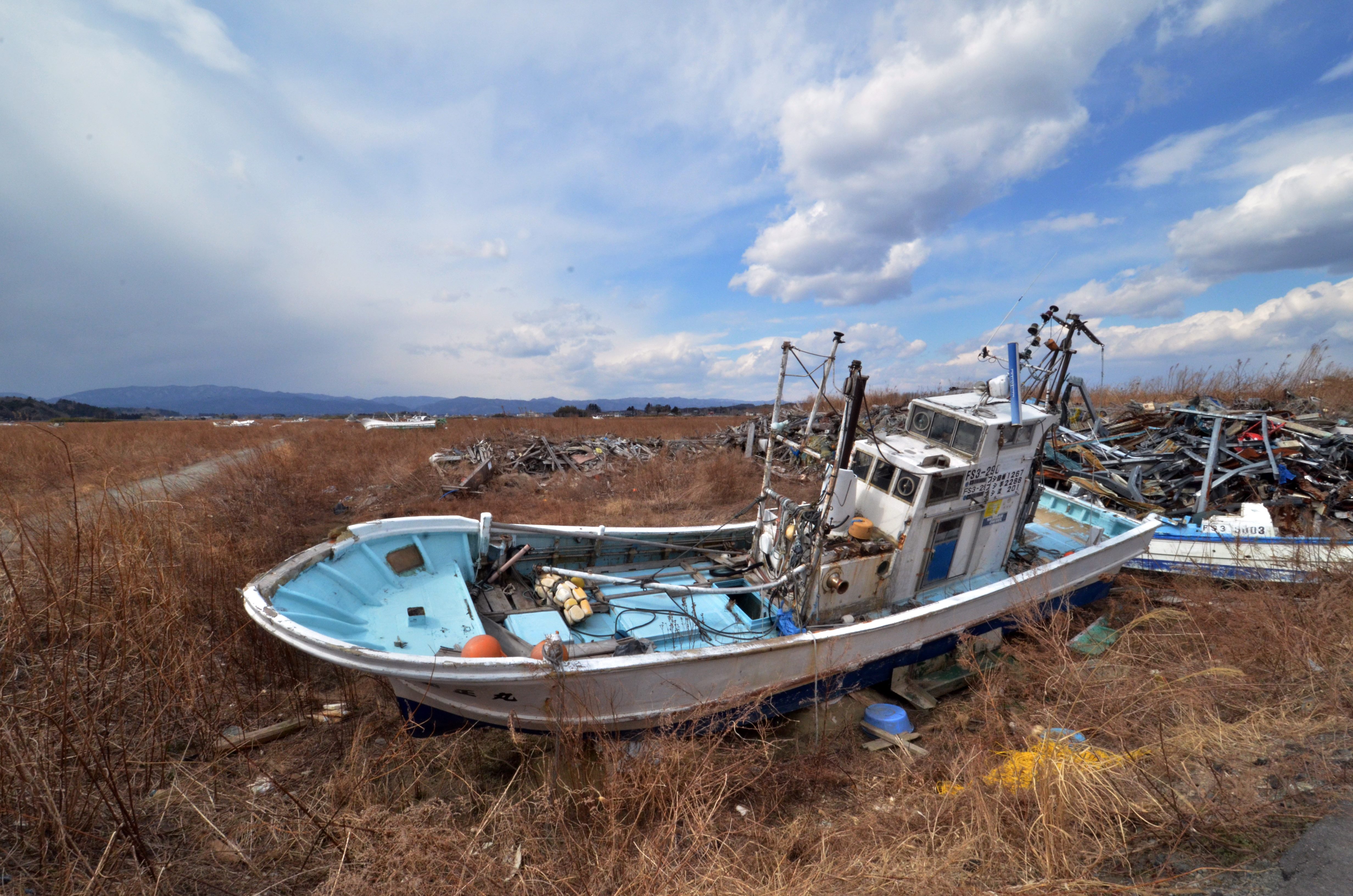 Fishing boats sit grounded on land years after the disaster in Namie, near the striken TEPCO Fukushima Dai-ichi nuclear plant in Fukushima prefecture on March 10, 2014, one day before the third anniversary of March 11 massive earthquake and tsunami.