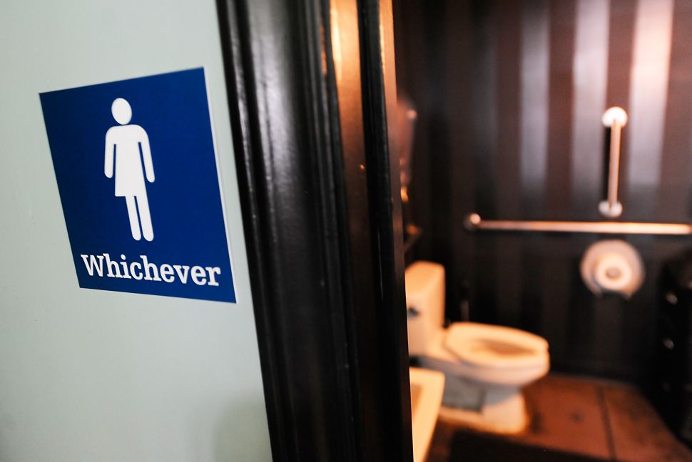 A gender neutral sign is posted outside a bathrooms at Oval Park Grill on May 11, 2016 in Durham, North Carolina. 