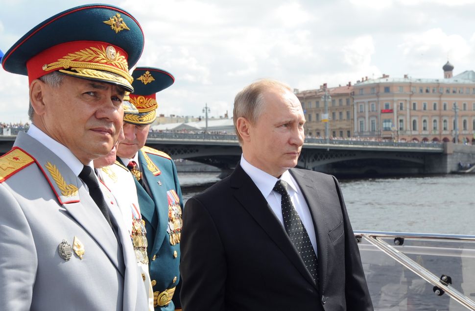 Russian President Vladimir Putin (R) and Defence Minister Sergei Shoigu (L) attend the celebration of Russia's Navy Day in Saint Petersburg on July 31, 2016. / AFP / SPUTNIK / Mikhail KLIMENTIEV