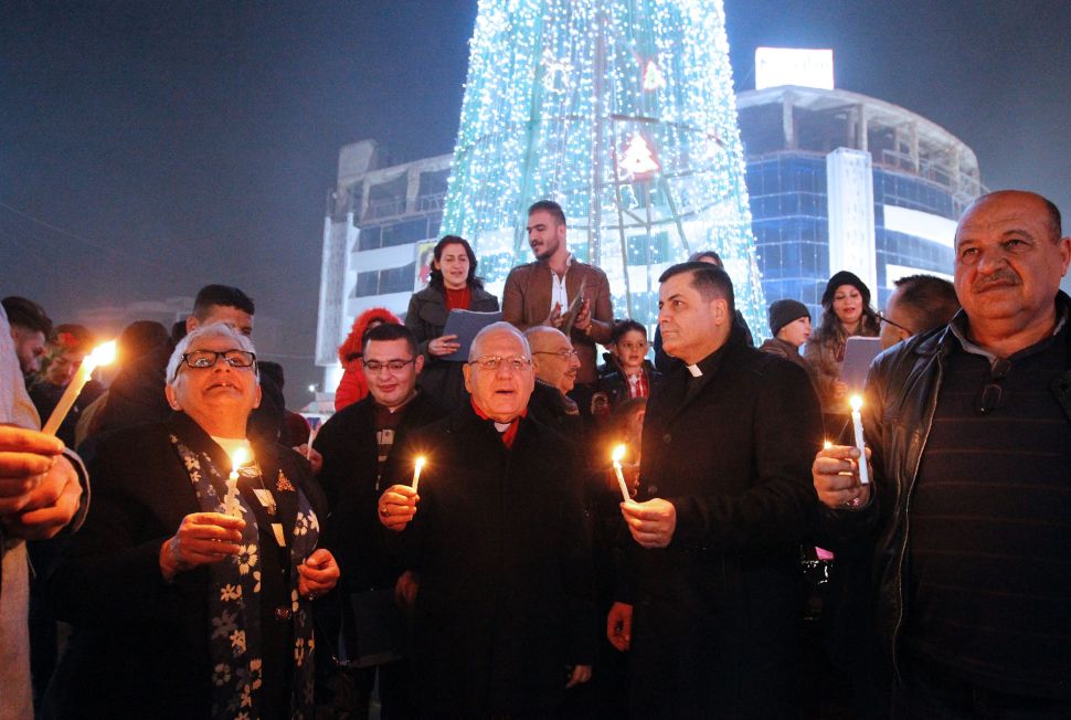 Iraqis gather at the al-Mansour square with Archbishop Louis Sako patriarch of the Chaldean Church in Iraq during Christmas and New Years eve celebrations in Baghdad on December 31, 2016.