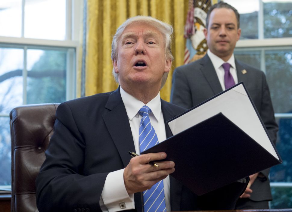President Donald Trump signs an executive order, which effects foreign NGOs that help with abortion, in the Oval Office of the White House in Washington, DC, January 23, 2017.