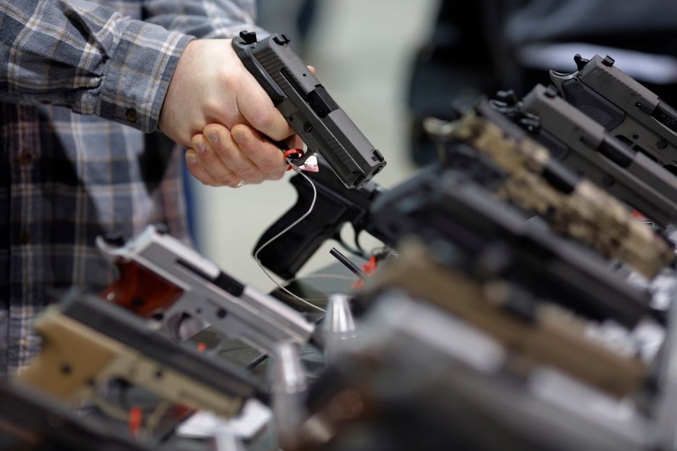 A visitor holds a pistol at a gun display during a National Rifle Association outdoor sports trade show on February 10, 2017 in Harrisburg, Pennsylvania. The Great American Outdoor Show, a nine day event celebrating hunting, fishing and outdoor traditions, features over 1,000 exhibitors ranging from shooting manufacturers to outfitters to fishing boats and RVs, and archery to art. / AFP / DOMINICK REUTER