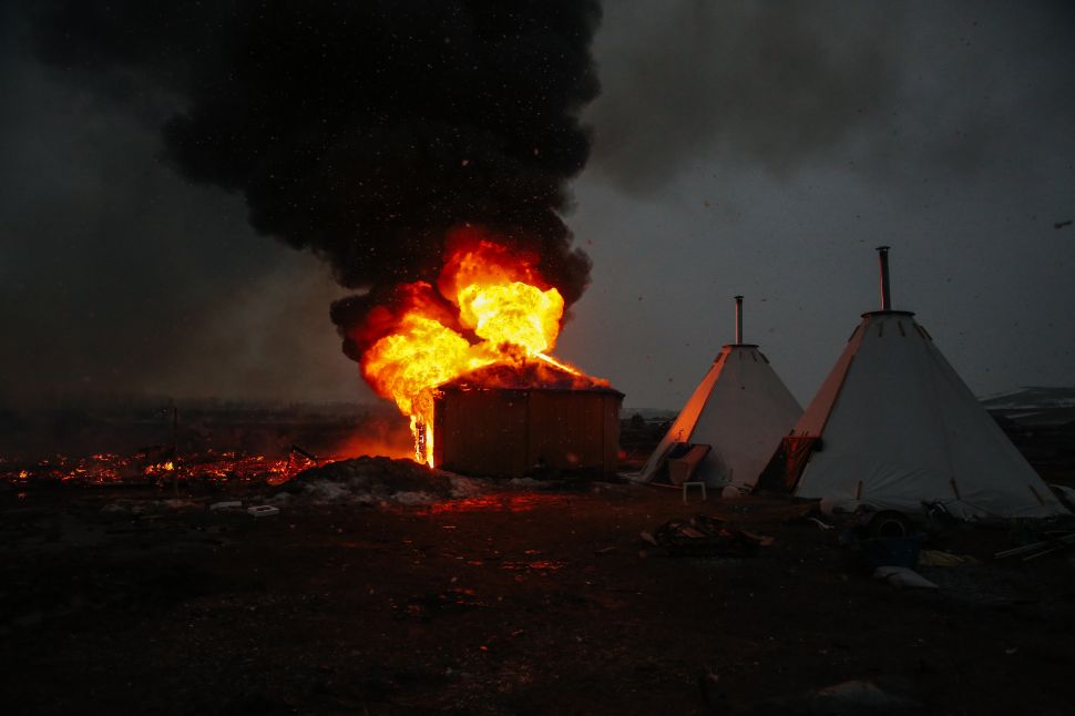 Campers set structures on fire in preparation of the deadline to leave the protest camp on February 22, 2017 in Cannon Ball, North Dakota.