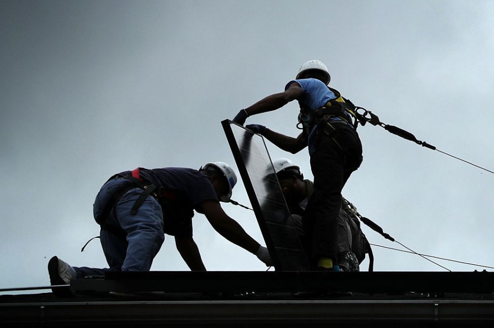 WASHINGTON, DC - MAY 03: Workers put solar panels down during an installation May 3, 2106 in Washington, DC. The installation marked the one millionth in the U.S. in the past 40 years. It has been predicted that the U.S. will reach 2 million installations in two years. (Photo by Alex Wong/Getty Images)