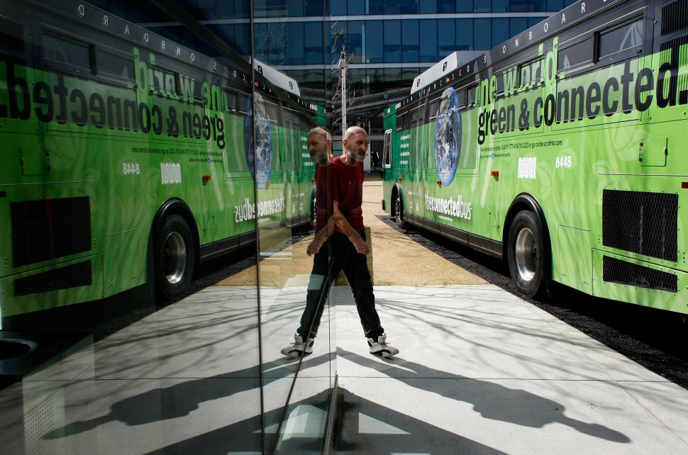 SAN FRANCISCO - FEBRUARY 20: A pedestrian walks by the Connected Bus, a new bus with high-tech features, February 20, 2008 in San Francisco, California. The Connected Bus is part of an innovated transit pilot program operated by San Francisco MUNI in partnership with Cisco Internet Business Solutions. The 95 percent emissions-free hybrid bus features high speed wireless internet access, live route information and wait times via touchscreen monitors and a "Green Gauge" that gives information about the environmental impact of the bus as it travels through the city. (Photo by Justin Sullivan/Getty Images)