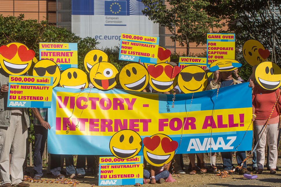 BRUSSELS, BELGIUM - AUGUST 30: Members of the global civic movement AVAAZ gather for a celebratory Emoji-flashmob by wearing masks with smiley emoji faces and posters that read 'Victory - Internet for all!' and 'Net Neutrality Now! EU listened' on August 30, 2016 in Brussels, Belgium. Europe introduced the first law in its history to protect internet democracy.