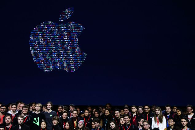 People gathered together to take a group photo with Apple's logo at Apple's annual Worldwide Developers Conference at the Bill Graham Civic Auditorium in San Francisco, California, on June 13, 2016. / AFP / GABRIELLE LURIE (Photo credit should read GABRIELLE LURIE/AFP/Getty Images)