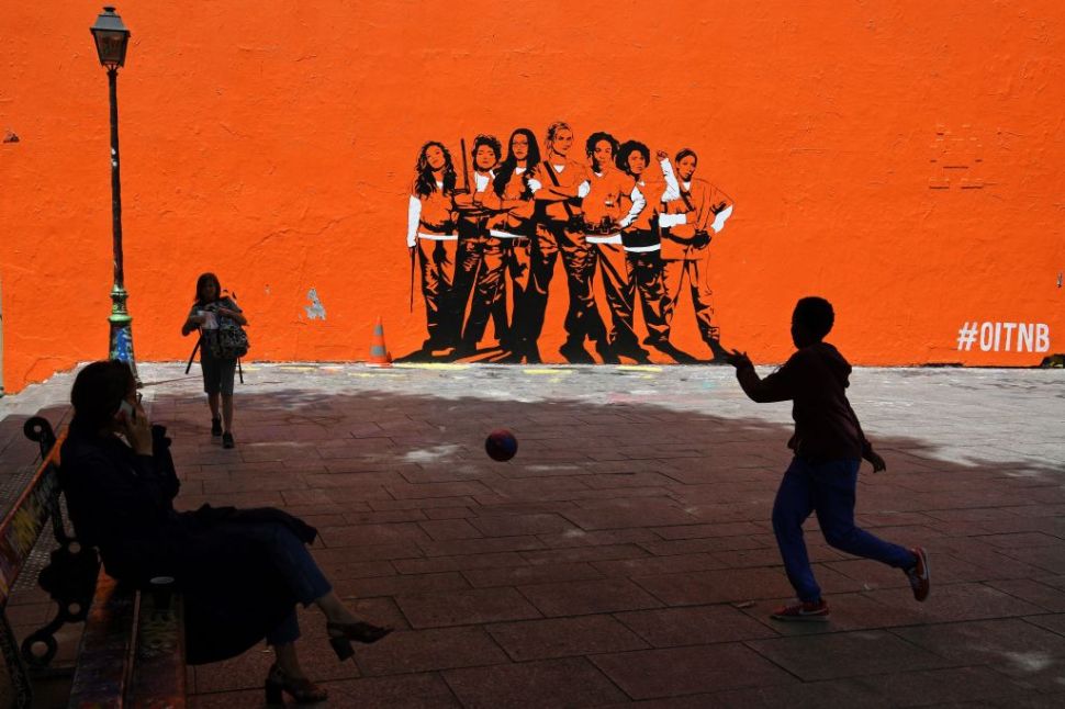 A boy plays football by a mural painting depicting the upcoming US series "Orange Is the New Black" to be shown on Netflix, on June 9, 2017 in Paris . / AFP PHOTO / CHRISTOPHE ARCHAMBAULT (Photo credit should read CHRISTOPHE ARCHAMBAULT/AFP/Getty Images)