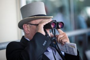 ASCOT, ENGLAND - JUNE 21: A racegoer looks through binoculars during a race at Royal Ascot 2017 at Ascot Racecourse on June 21, 2017 in Ascot, England. The five-day Royal Ascot meeting is one of the highlights of the horse racing calendar and has been held at the famous Berkshire course since 1711. (Photo by Jack Taylor/Getty Images)