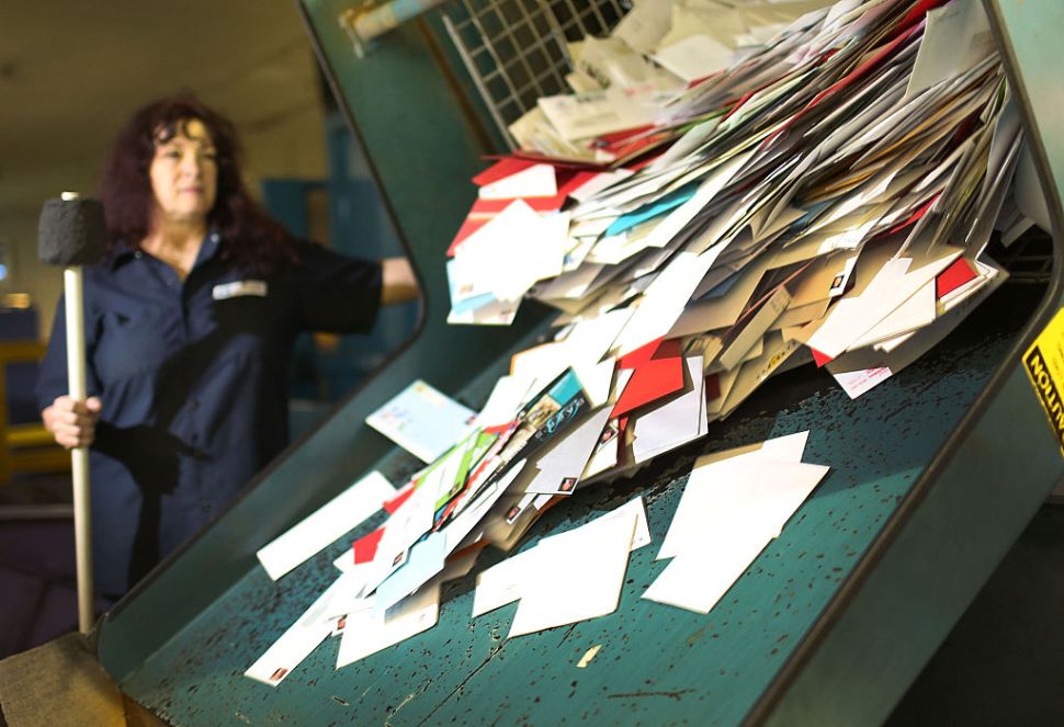 MIAMI, FL - DECEMBER 14: Susan Bird, a U.S. Postal Service mail handler, works to sort mail at a Processing and Distribution Center on the busiest mailing day of the year for the U.S. Postal Service on December 14, 2015 in Miami, Florida. With 10 days to go until Christmas eve, today the postal service was expecting 612 million pieces of mail to be sent, from first class letters to priority packages. (Photo by Joe Raedle/Getty Images)