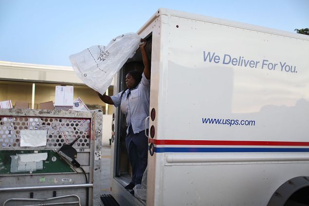 MIAMI, FL - DECEMBER 14: Taquinnia Lee, a United States Postal Service mail handler, works to unload her mail truck at the Processing and Distribution Center after collecting mail on the busiest mailing day of the year for the U.S. Postal Service on December 14, 2015 in Miami, Florida. With 10 days to go until Christmas eve, today the postal service was expecting 612 million pieces of mail to be sent, from first class letters to priority packages. (Photo by Joe Raedle/Getty Images)