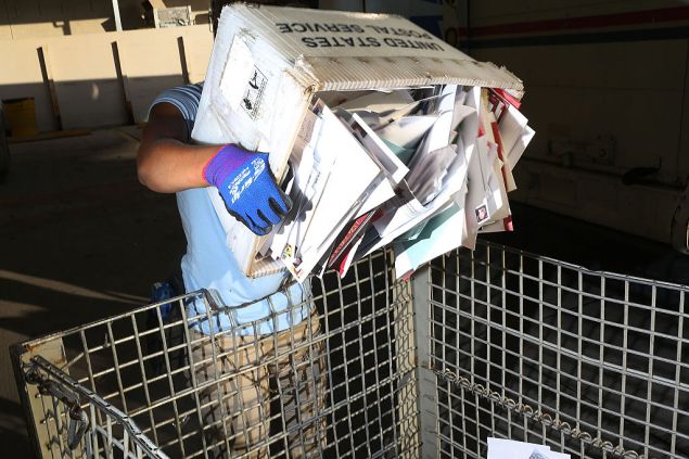 MIAMI, FL - DECEMBER 14: Shantel Hill, a City Carrier Assistant to the United States Postal Service, works to unload her mail truck at the Processing and Distribution Center after collecting mail on the busiest mailing day of the year for the U.S. Postal Service on December 14, 2015 in Miami, Florida. With 10 days to go until Christmas eve, today the postal service was expecting 612 million pieces of mail to be sent, from first class letters to priority packages. (Photo by Joe Raedle/Getty Images)