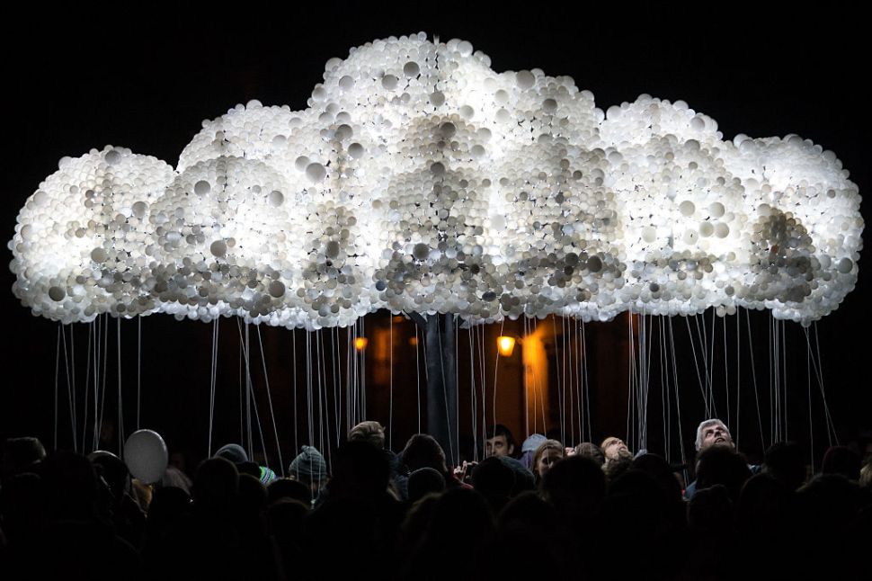 People take part to an interactive art installation "Cloud" created from 6,000 lightbulbs by Canadian artists Caitlind RC Brown & Wayne Garrett, during "The White Night", a night-time art festival in Bratislava, Slovakia on October 08, 2016. / AFP / VLADIMIR SIMICEK (Photo credit should read VLADIMIR SIMICEK/AFP/Getty Images)