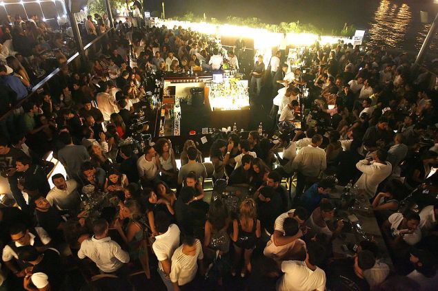 Lebanese enjoy a night out at the open air Sky Bar in Beirut, late 18 July 2007. Lebanon's political paralysis and bomb blasts may have deterred summer tourists but it's a case of "crisis, what crisis?" for a small elite: the hardcore party crowds of Beirut and its modern-day protege Dubai. After dancing the night away at the rooftop Sky Bar, which packs in 2,500 a night, weekend visitors from Dubai sleep it off at one of Beirut's luxury hotels before wearily heading for a pool and bar-restaurant overlooking the Med in time for sundowners. AFP PHOTO/MARWAN NAMANI (Photo credit should read MARWAN NAAMANI/AFP/Getty Images)
