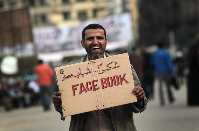 CAIRO, EGYPT - FEBRUARY 03: An anti-government demonstrator holds a sign during clashes on February 3, 2011 in Cairo, Egypt. Initial protests against the government were organized on internet social media. The Egyptian army positioned tanks between the protesters during a second day of violent skirmishes in and around Tahrir Square in Cairo. (Photo by John Moore/Getty Images)