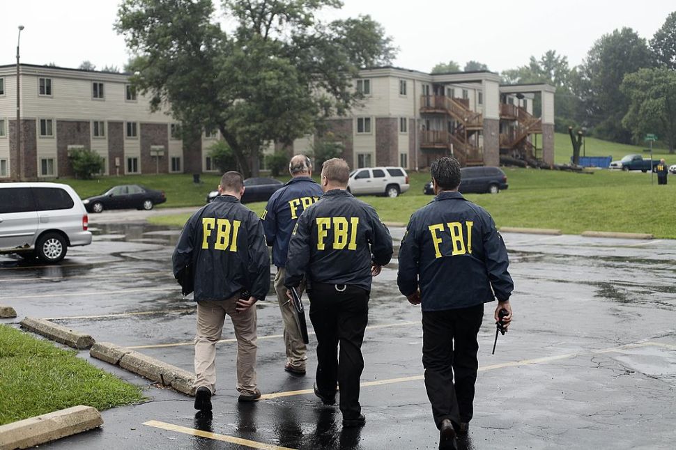 FBI Agents on August 16, 2014, investigate the shooting death of 18-year-old Michael Brown at the location where he was killed on Canfield Drive in Ferguson, Missouri. Vandals attacked stores in Ferguson early August 9, hours after police said the unarmed black teenager was a robbery suspect. The allegation reignited anger in the town, a St. Louis suburb in the state of Missouri, that has endured on-and-off rioting since Brown was killed on August 9. AFP PHOTO/Joshua LOTT (Photo credit should read Joshua LOTT/AFP/Getty Images)