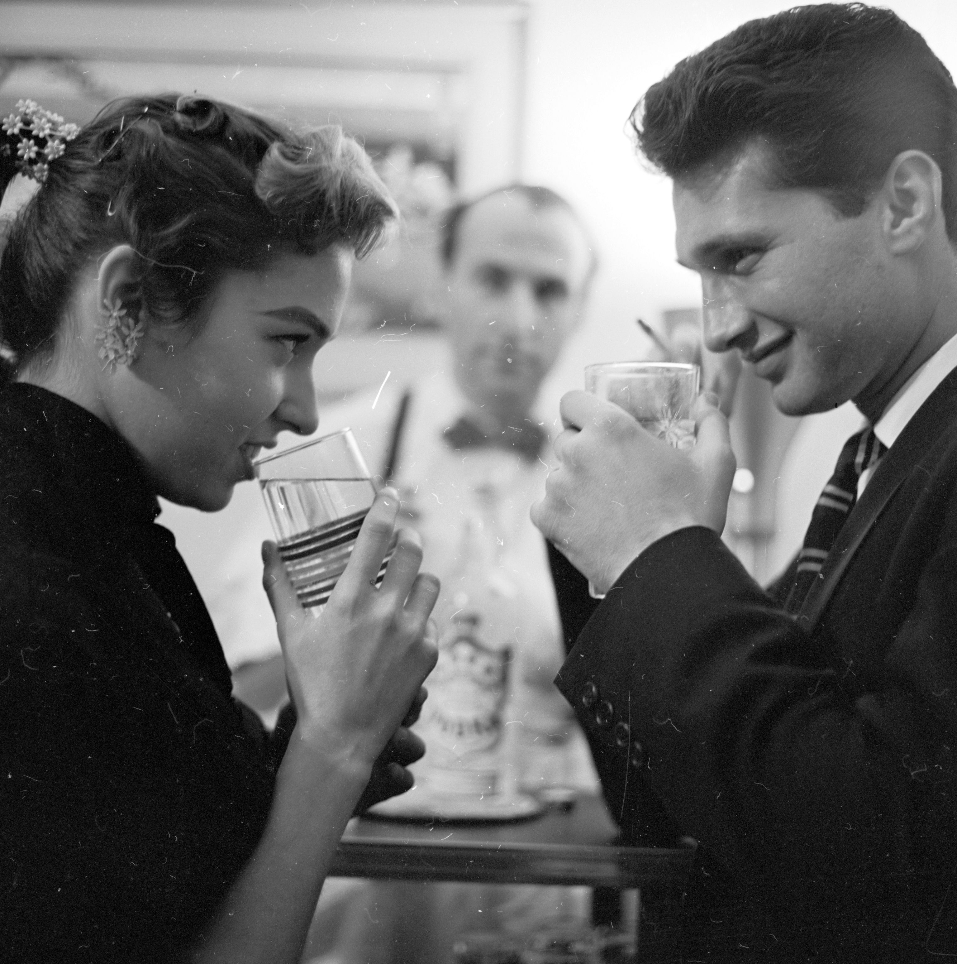 circa 1955: A bartender waits attentively on a young couple out on a date.