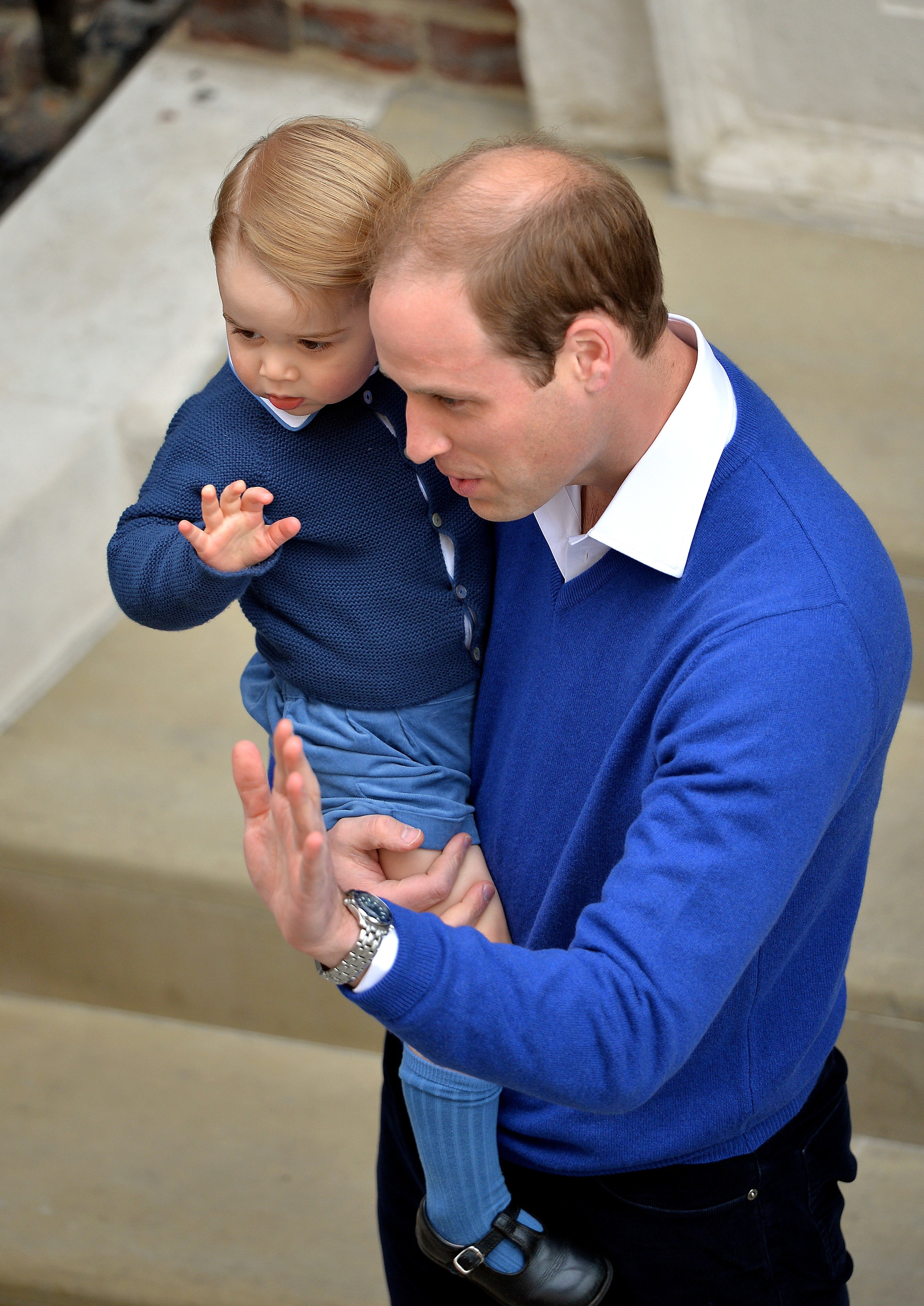 Britain's Prince William, Duke of Cambridge (R), and his son Prince George of Cambridge (L) wave as they return to the Lindo Wing at St Mary's Hospital in central London, on May 2, 2015 where his wife Catherine, Duchess of Cambridge, gave birth to their second child, a baby girl, earlier in the day. The Duchess of Cambridge was safely delivered of a daughter weighing 8lbs 3oz, Kensington Palace announced. The newly-born Princess of Cambridge is fourth in line to the British throne. AFP PHOTO / POOL / JOHN STILLWELL (Photo credit should read JOHN STILLWELL/AFP/Getty Images)