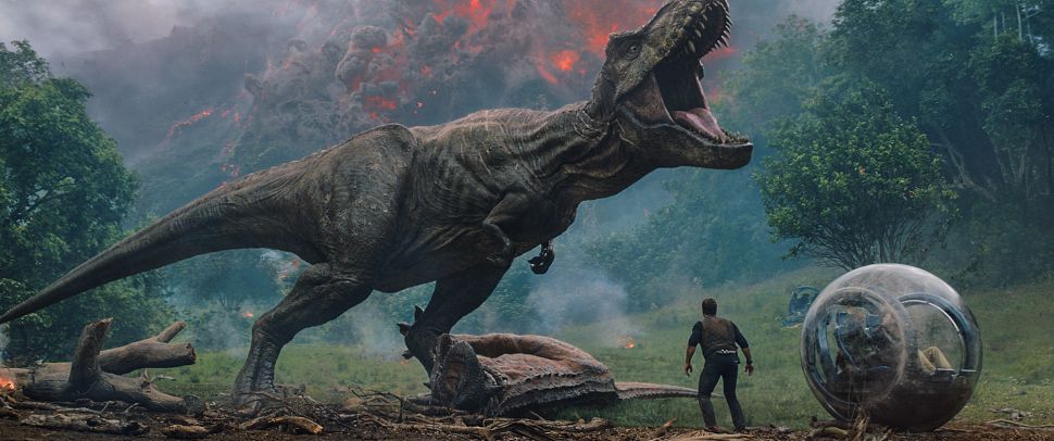 Owen (CHRIS PRATT) meets the vicious T. rex in "Jurassic World: Fallen Kingdom." When the island's dormant volcano begins roaring to life, Owen and Claire (BRYCE DALLAS HOWARD) mount a campaign to rescue the remaining dinosaurs from this extinction-level event. Welcome to "Jurassic World: Fallen Kingdom."