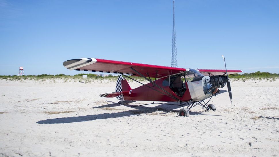 Coast Guard personnel and other various agencies stand in front of a plane on a secured beach on the southeast side of Training Center Cape May after it landed illegally and the pilot ran off.