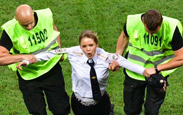 A member of Pussy Riot is escorted by stewards during the Russia 2018 World Cup final football match between France and Croatia. 