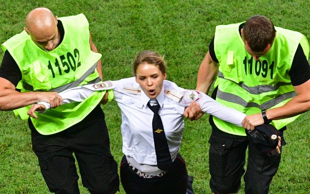 A member of Pussy Riot is escorted by stewards during the Russia 2018 World Cup final football match between France and Croatia.