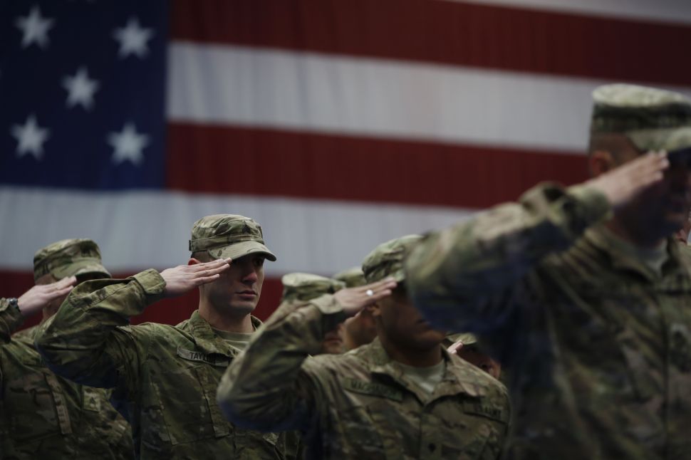FORT KNOX, KY - FEBRUARY 27: Soldiers from the U.S. Army's 3rd Brigade Combat Team, 1st Infantry Division, salute during the playing of the Star Spangled Banner during a homecoming ceremony in the Natcher Physical Fitness Center on Fort Knox on February 27, 2014 in Fort Knox, Kentucky. About 100 soldiers returned to Fort Knox after a nine-month combat deployment conducting village stability operations and working alongside Afghan military and police forces. (Photo by Luke Sharrett/Getty Images)