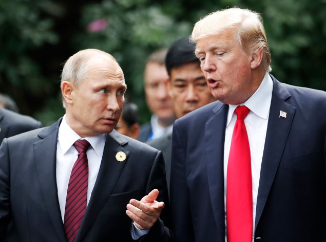 President Donald Trump and Russia's President Vladimir Putin talk as they make their way to take the "family photo" during the Asia-Pacific Economic Cooperation (APEC) leaders' summit in the central Vietnamese city of Danang on November 11, 2017.