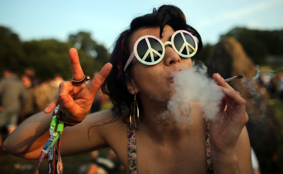 Actress Rudina Hatipi smokes as she joins fellow revellers as they gather for the sunset at the stone circle at the 2013 Glastonbury Festival.