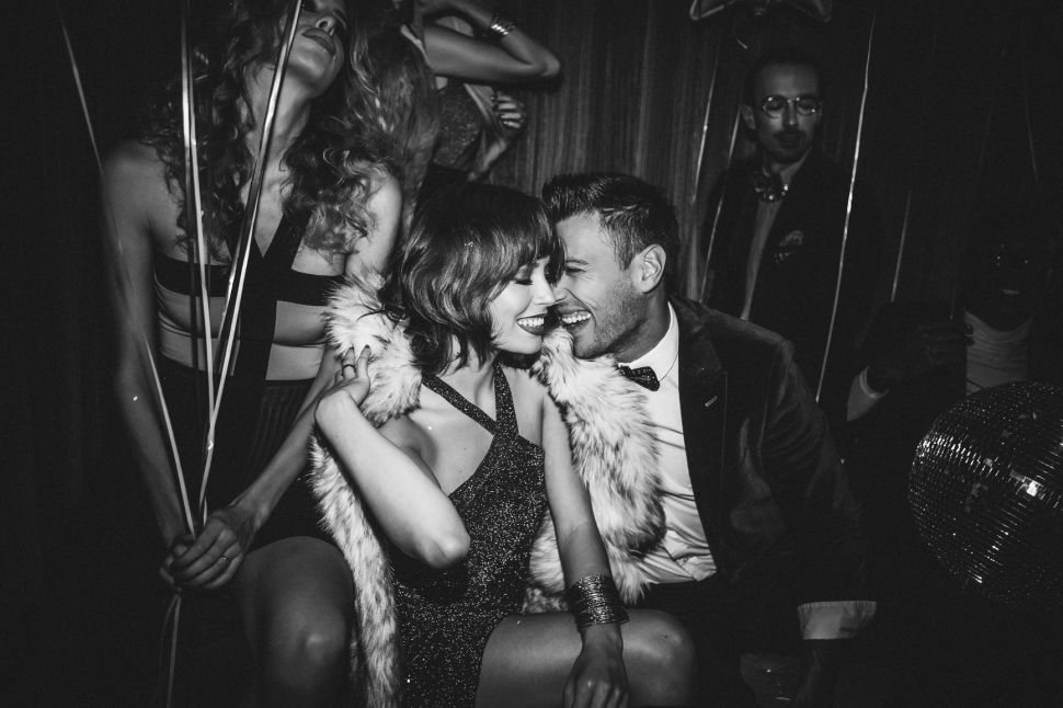 A man and woman embrace at a party.