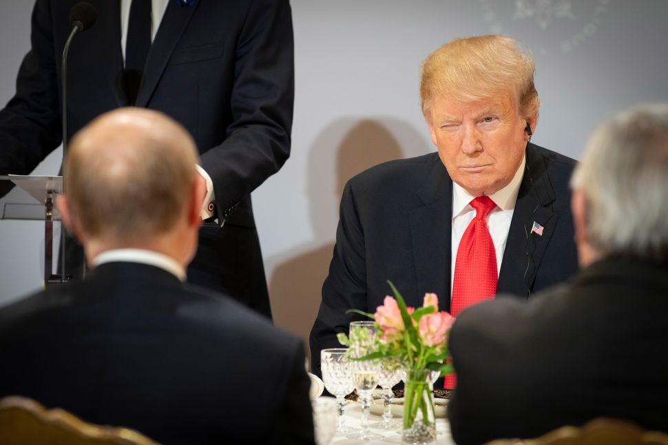 President Donald Trump sits opposite Russian President Vladimir Putin during lunch at the Élysée Palace.