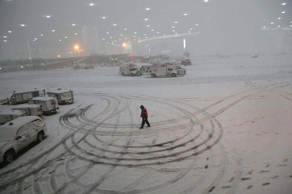 NEWARK, NJ - NOVEMBER 15: A ground crew member walks through the snow at the Newark Liberty International Airport on November 15, 2018 in Newark, New Jersey. The early season storm caused flight cancellations in much of the northeast.