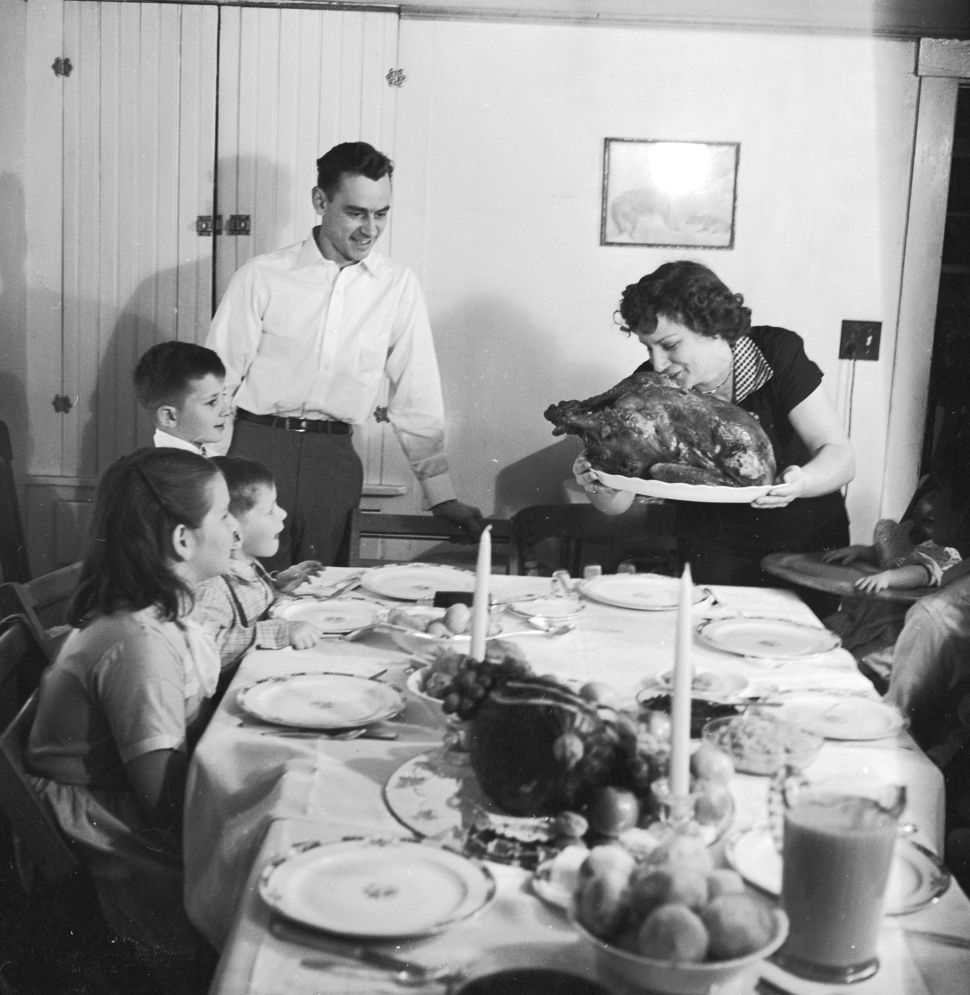 A family celebrates Thanksgiving with turkey circa 1955.