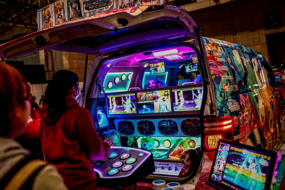 A woman plays a video game out of the back of a modified vehicle during Game Party Japan 2015 at the Makuhari Messe in Tokyo, Japan.