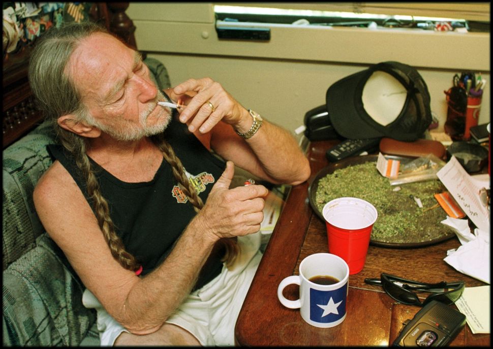 American country singer Willie Nelson takes a drag off a joint while relaxing at his home in Texas.