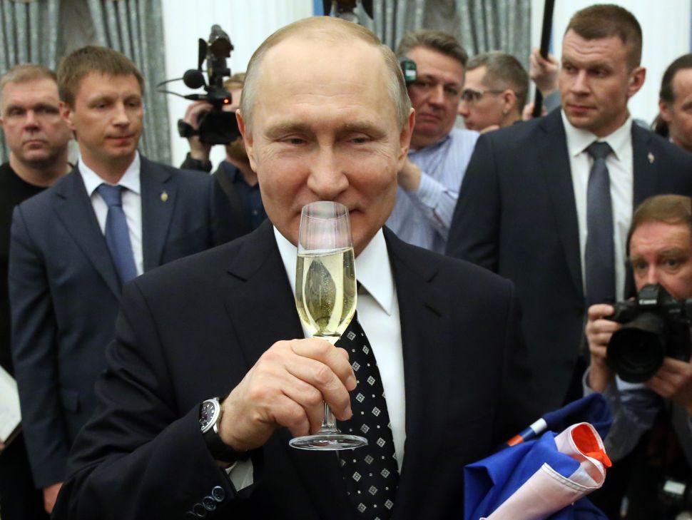 ) Russian President Vladimir Putin drinks champagne during a reception with paralympic athletes at the Kremlin, Russia, March 2018.