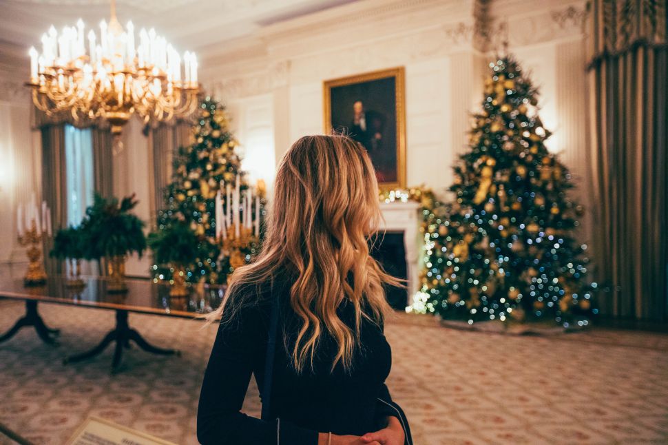 A woman looks at a Christmas tree.