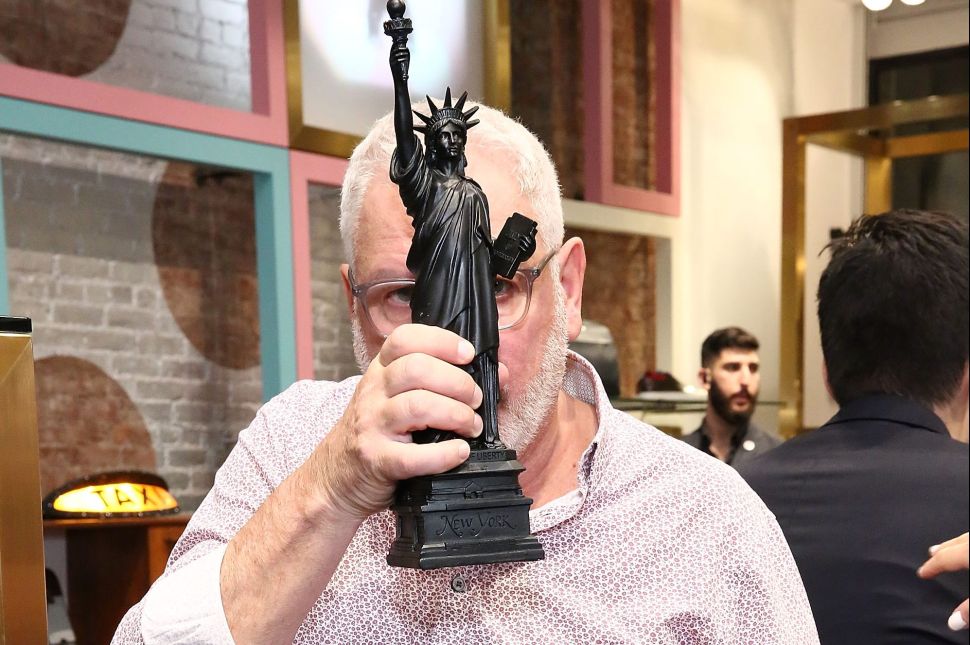 Ray Kelvin obscures his face with a mini-size Statue of Liberty at the Ted Baker Wooster VIP Event on September 22, 2016 in New York City.